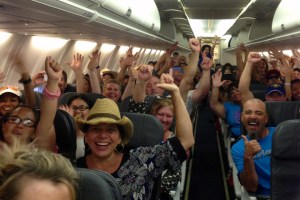 Customers on a relief flight celebrate after they were told they would all get free cheeseburgers.