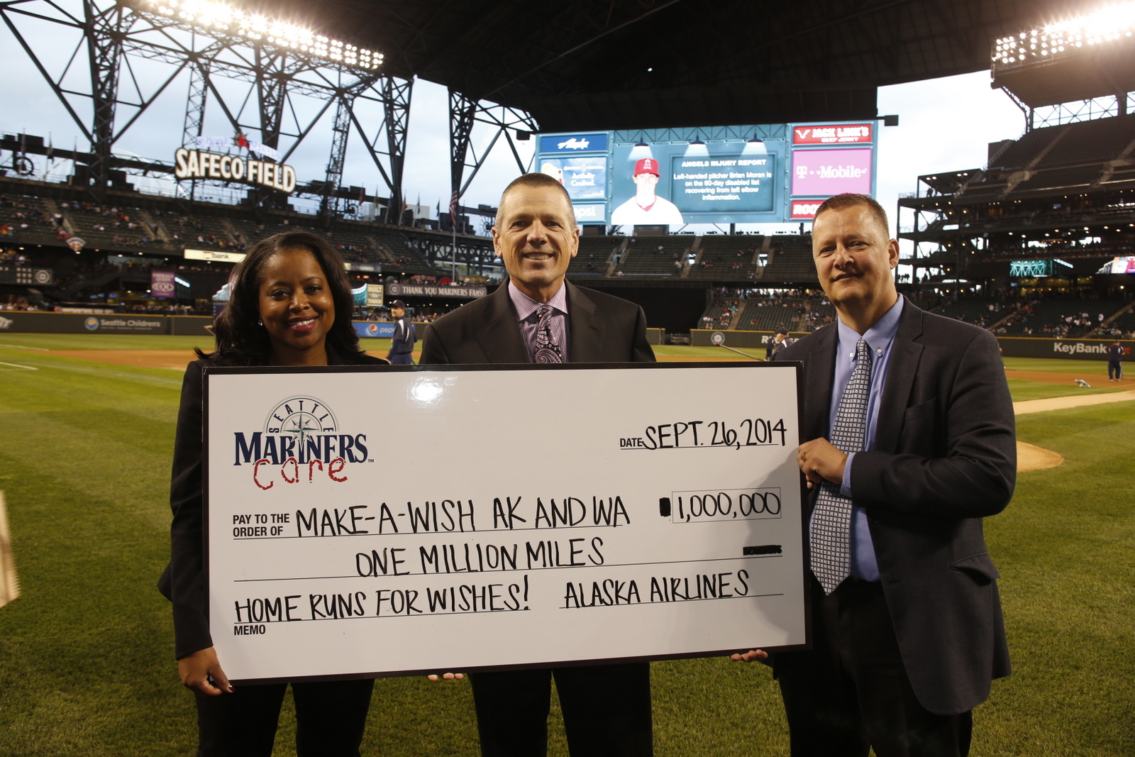 Alaska Airlines’ Shaunta Hyde presents 1 million miles to Barry McConnell, Make-a-Wish Alaska and Washington chapter president and CEO, and Make-A-Wish board chair Mitch Hansen before a Mariners game on Friday, Sept. 26.