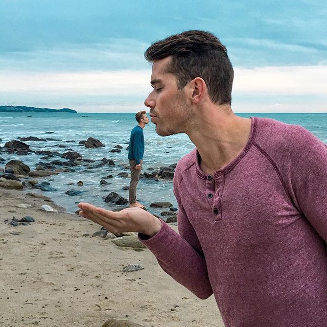This is a photo of two men kissing on the beach.