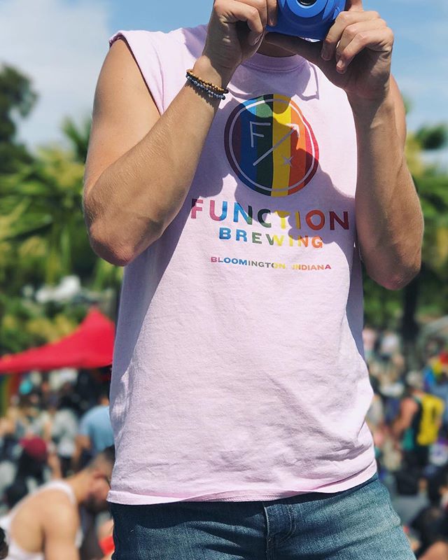 This is a picture of a man taking a picture wearing a rainbow Function Brewing tank top.