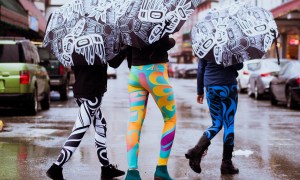 This is a photo of three women walking on a rainy street in bright leggings and umbrellas featuring contemporary Alaska Native artwork by Trickster Co.