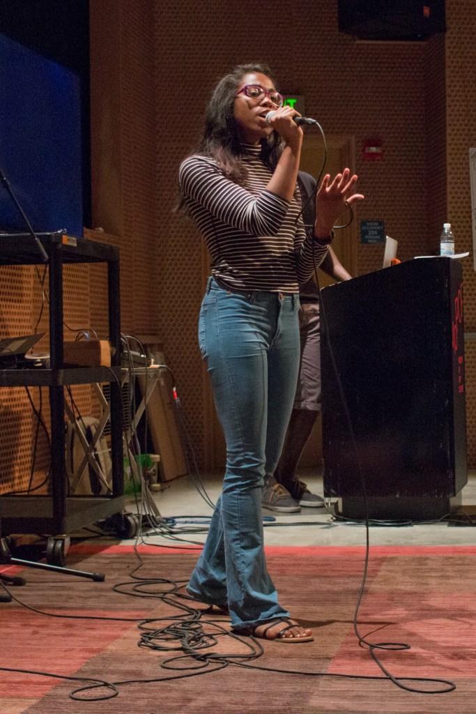 This is a photo of a young woman singing on a practice stage.
